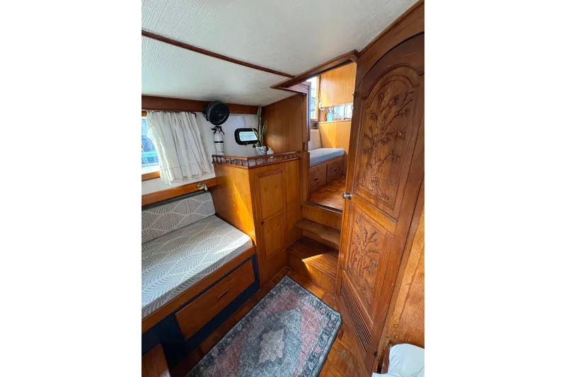 Slide: The Image of 1978 CHB 35 boat interior with wooden cabinetry, seating, and decorative door. - 34