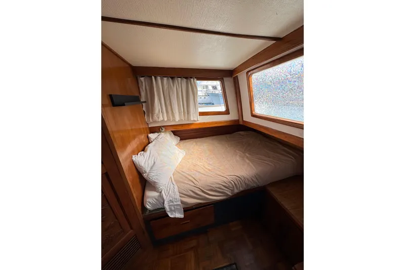 Slide: The Image of Cozy cabin interior of a 1978 CHB 35 boat with wooden accents and a bed. - 37