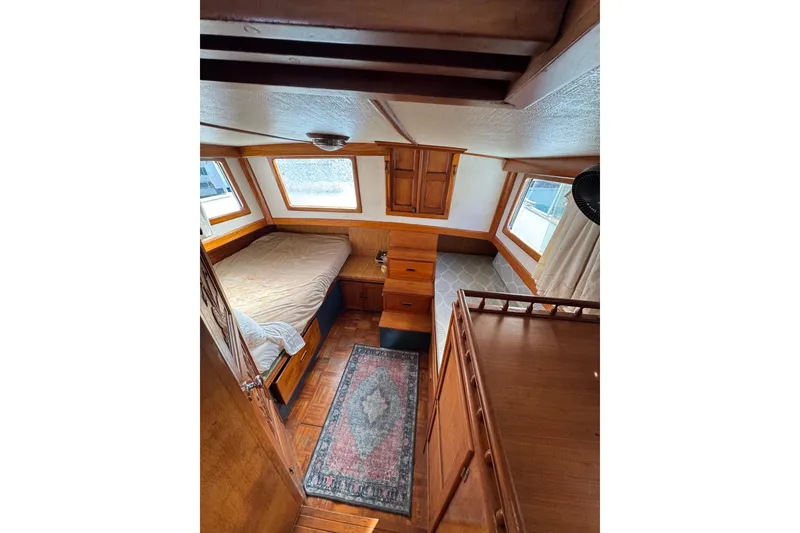 Slide: The Image of Cozy cabin interior of 1978 CHB 35 boat with bed, wooden furniture, and windows. - 38