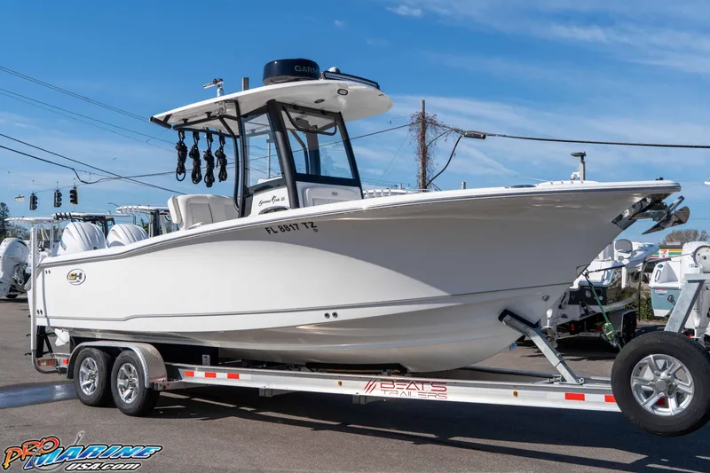 The Image of 2025 Sea Hunt Gamefish 25 boat on trailer, displayed outdoors under clear blue sky. - 1