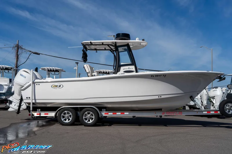 Slide: The Image of 2025 Sea Hunt Gamefish 25 boat on trailer, displayed outdoors under clear sky. - 13