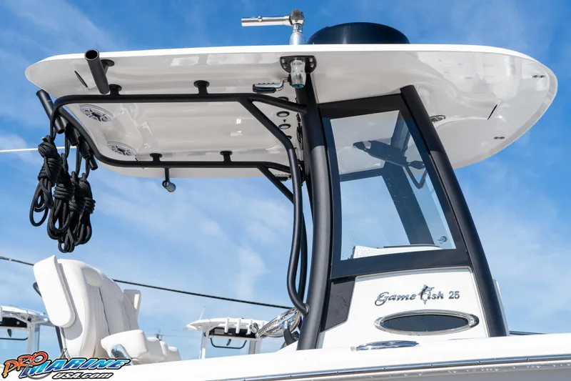 Slide: The Image of 2025 Sea Hunt Gamefish 25 boat with T-top and sleek design against blue sky. - 15