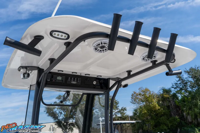 Slide: The Image of 2025 Sea Hunt Gamefish 25 T-top with rod holders and speakers, under clear blue sky. - 22