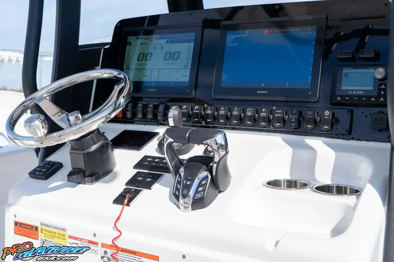 Slide: The Image of 2025 Sea Hunt Gamefish 25 dashboard with steering wheel, controls, and digital displays. - 25