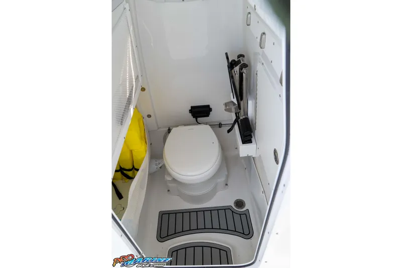 Slide: The Image of 2025 Sea Hunt Gamefish 25 boat interior with compact marine toilet and storage. - 32