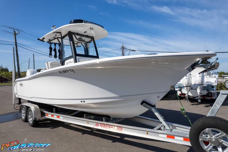 Slide: The Image of 2025 Sea Hunt Gamefish 25 boat on trailer, displayed outdoors under clear blue sky. - 33