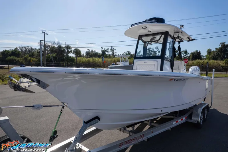 Slide: The Image of 2025 Sea Hunt Gamefish 25 boat on trailer, parked outdoors under clear sky. - 39