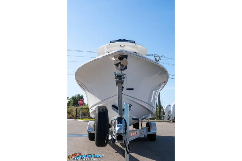 Slide: The Image of 2025 Sea Hunt Gamefish 25 boat on trailer, viewed from front, under clear blue sky. - 4
