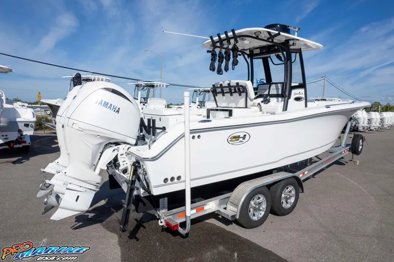 Slide: The Image of 2025 Sea Hunt Gamefish 25 boat on trailer with Yamaha engine, parked outdoors. - 48