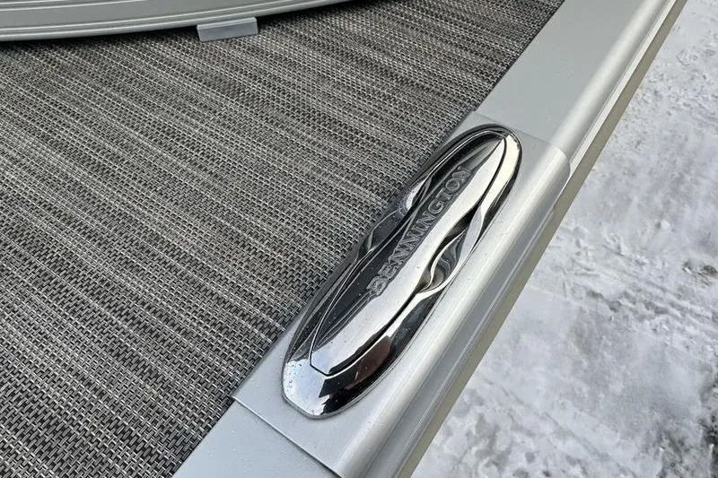 Slide: The Image of 2021 Bennington 23 LSB boat detail with chrome logo on textured surface. - 18