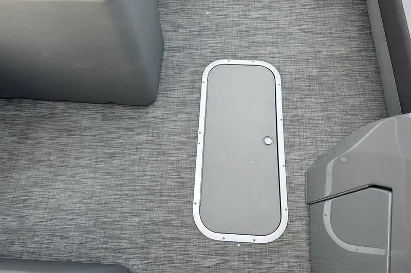 Slide: The Image of 2021 Bennington 23 LSB boat interior with gray flooring and storage hatch. - 24