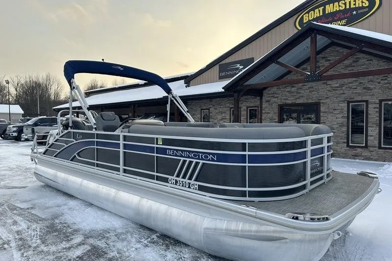 Slide: The Image of 2021 Bennington 23 LSB pontoon boat parked outside dealership in winter setting. - 4