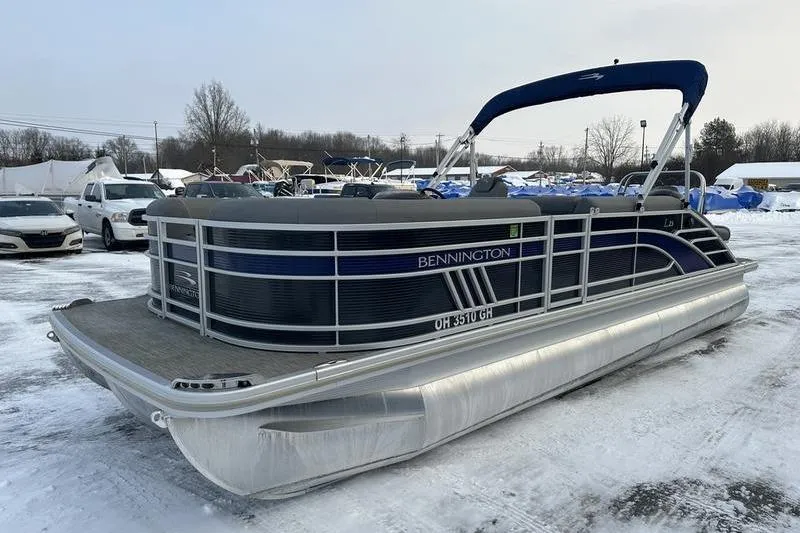 Slide: The Image of 2021 Bennington 23 LSB pontoon boat on snowy lot, featuring sleek design and blue accents. - 5