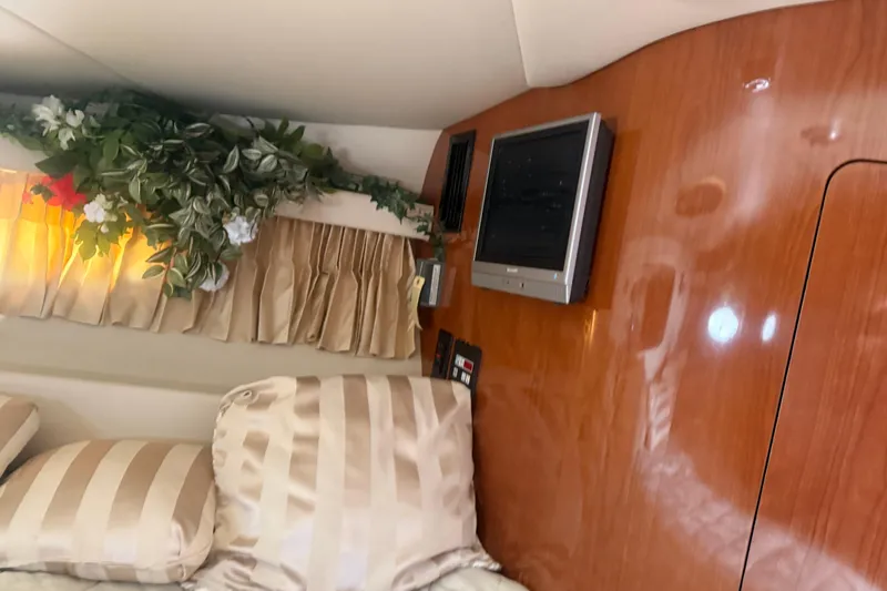 Slide: The Image of Luxurious interior of 2005 Regal Commodore 3880 with TV, floral decor, and striped bedding. - 16