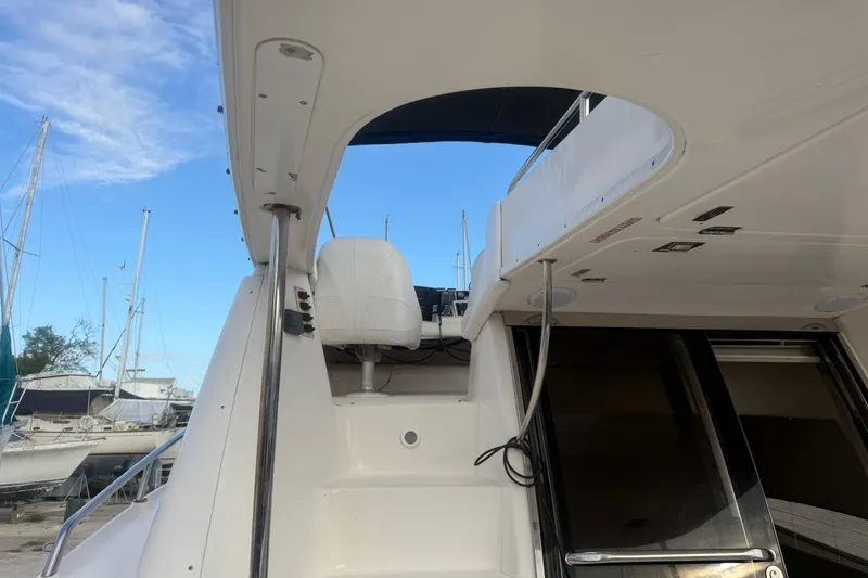 Slide: The Image of 2005 Regal Commodore 3880 yacht interior with stairs and seating, under a clear blue sky. - 2