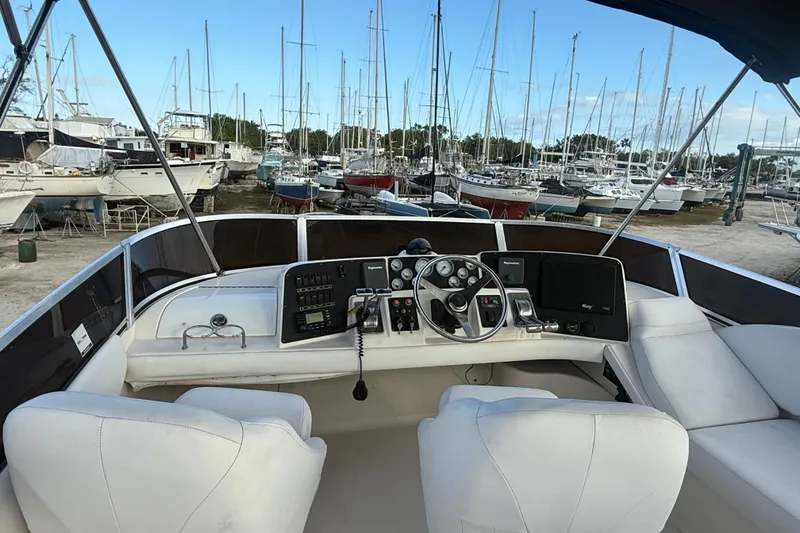 Slide: The Image of 2005 Regal Commodore 3880 yacht cockpit with steering wheel, controls, and marina view. - 4