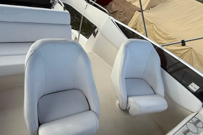 Slide: The Image of 2005 Regal Commodore 3880 boat interior with white seating and helm chairs. - 6