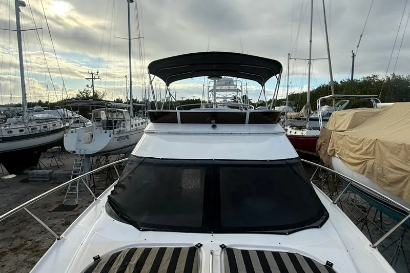 Slide: The Image of 2005 Regal Commodore 3880 yacht docked among other boats under a cloudy sky. - 9