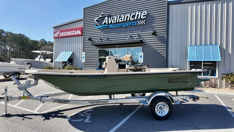 The Image of 2025 Carolina Skiff E18 JVX CC boat on trailer at Avalanche Motorsports dealership. - 1