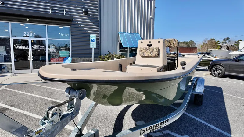 Slide: The Image of 2025 Carolina Skiff E18 JVX CC boat on trailer outside dealership. - 3