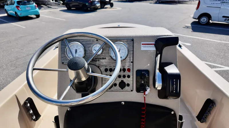 Slide: The Image of 2025 Carolina Skiff E18 JVX CC boat dashboard with steering wheel and controls. - 8