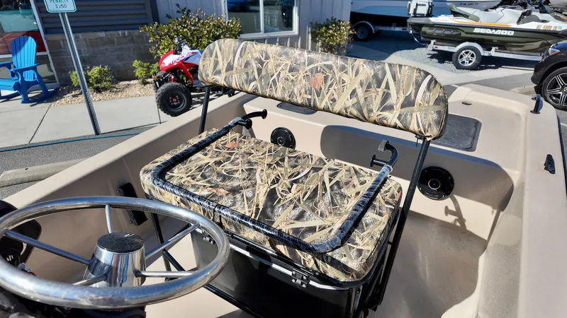 Slide: The Image of 2025 Carolina Skiff E18 JVX CC boat with camo seating and steering wheel. - 9