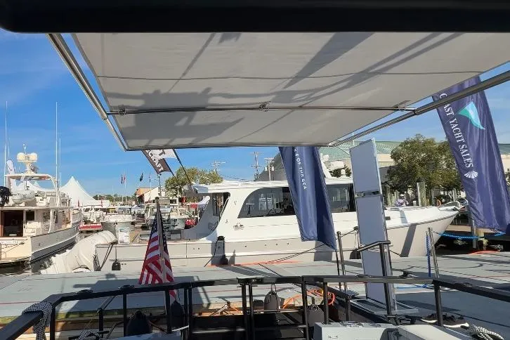 Slide: The Image of 2025 Targa 37 yacht docked at marina with flags and awning. - 24