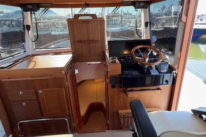 Slide: The Image of 2025 Targa 37 boat interior with wooden helm, steering wheel, and navigation equipment. - 25