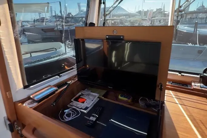 Slide: The Image of 2025 Targa 37 yacht interior with TV, remote, and marina view. - 27