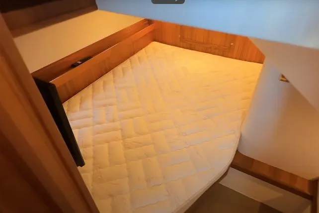 Slide: The Image of Cozy cabin bed in 2025 Targa 37 boat, featuring wooden accents and soft lighting. - 38