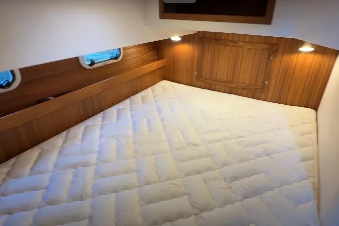 Slide: The Image of Cozy cabin interior of 2025 Targa 37 with wooden accents and comfortable bedding. - 39