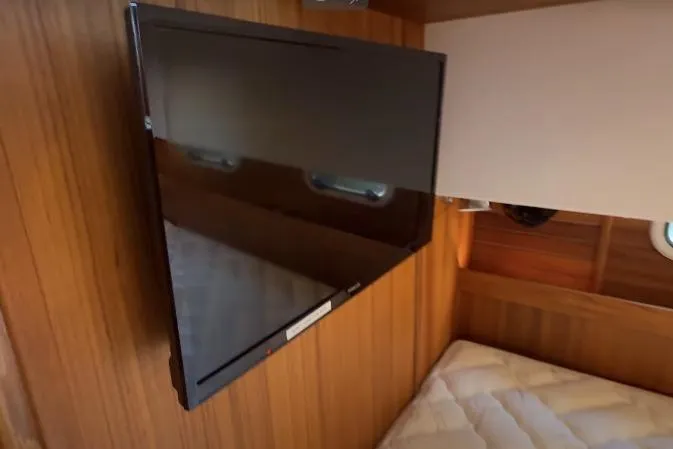 Slide: The Image of Flat-screen TV in Targa 37 yacht cabin, 2025 model, with wooden interior. - 40