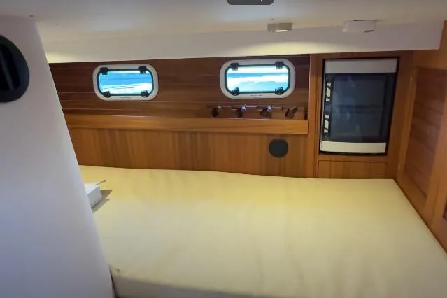 Slide: The Image of 2025 Targa 37 yacht cabin interior with wooden paneling and porthole windows. - 42