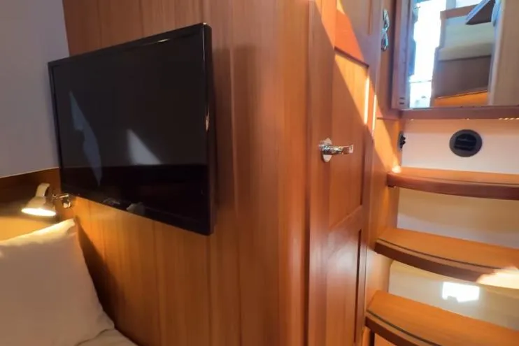 Slide: The Image of Interior of 2025 Targa 37 yacht with wooden paneling, TV, and stairs. - 45