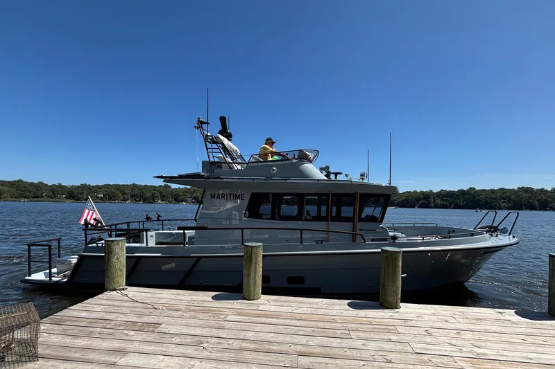 Slide: The Image of 2025 Targa 37 boat docked on a sunny day, featuring sleek design and American flag. - 54