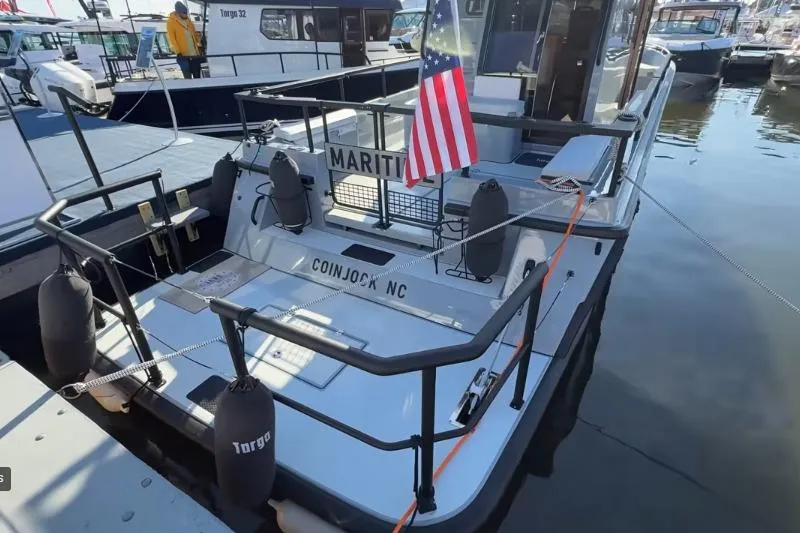 Slide: The Image of 2025 Targa 37 boat docked, displaying American flag, Coinjock NC. - 6