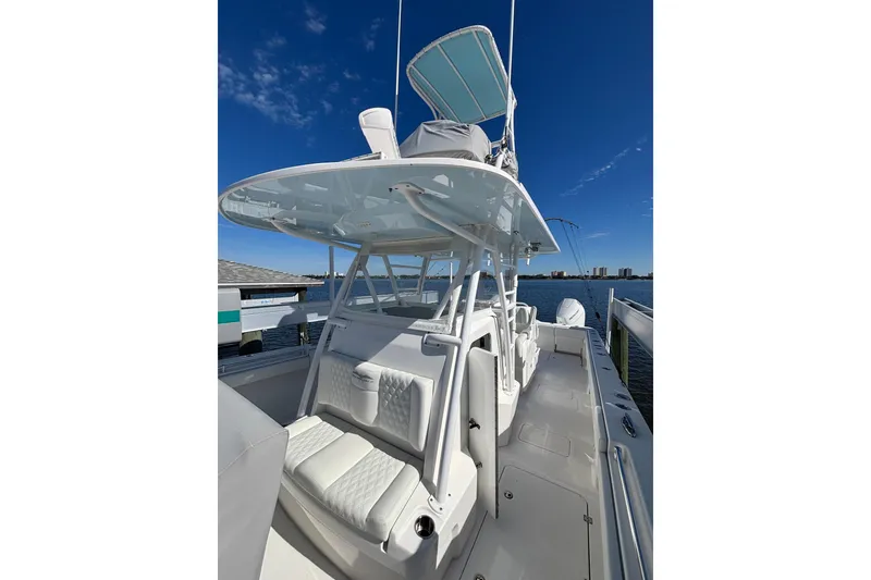 Slide: The Image of 2021 Invincible 35 Catamaran with sleek design, docked by the water under a clear blue sky. - 6