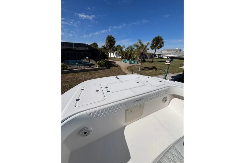 Slide: The Image of 2021 Invincible 35 Catamaran boat deck with clear sky and palm trees in the background. - 8