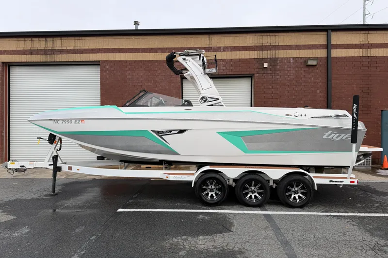 The Image of 2023 Tigé 24RZX boat on trailer, parked outside a brick building. - 0