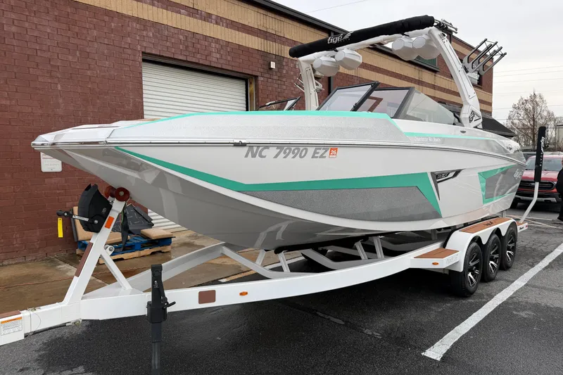 Slide: The Image of 2023 Tigé 24RZX boat on trailer, parked outside a brick building. - 1