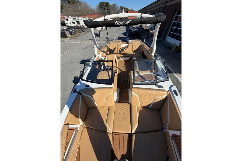 Slide: The Image of 2023 Tigé 24RZX boat with tan interior and sleek design in a parking area. - 10