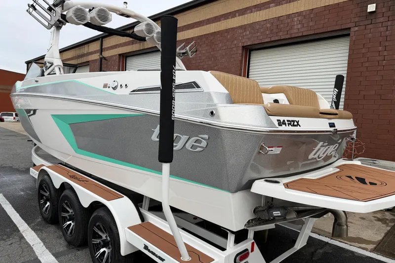 Slide: The Image of 2023 Tigé 24RZX boat with sleek design and modern features, parked on a trailer. - 2