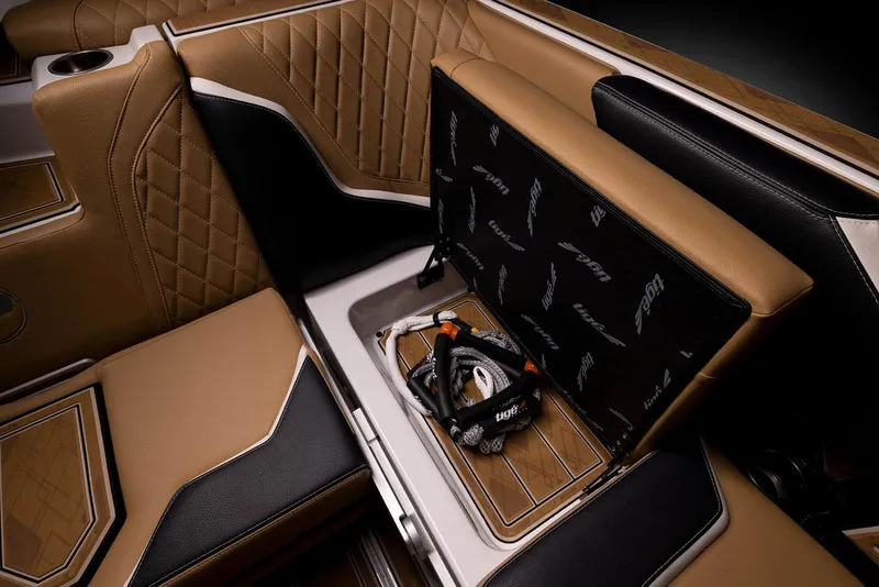 Slide: The Image of Manufacturer Provided Image: 2023 Tigé 24RZX boat interior storage compartment with tan and black upholstery. - 28