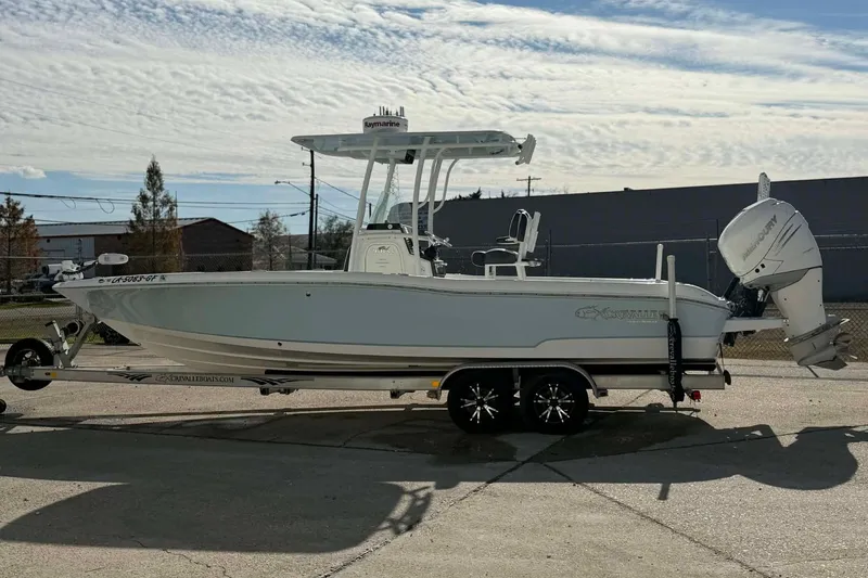 Slide: The Image of 2016 Crevalle 26 Bay boat on trailer, side view, under a partly cloudy sky. - 10