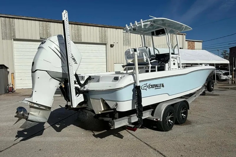 Slide: The Image of 2016 Crevalle 26 Bay boat on trailer, parked outside industrial building. - 2