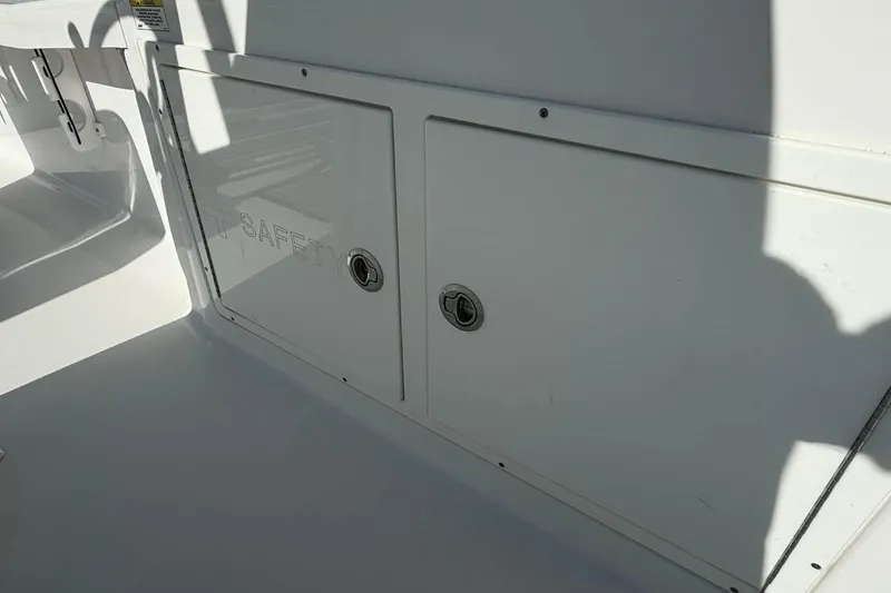 Slide: The Image of 2016 Crevalle 26 Bay boat storage compartment with safety label and shadow. - 23