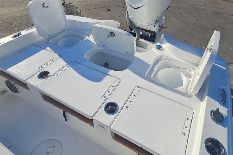 Slide: The Image of 2026 Sea Hunt BX 25 FS boat deck with open storage compartments and motor. - 11