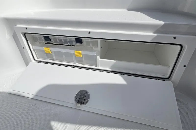 Slide: The Image of 2026 Sea Hunt BX 25 FS boat storage compartment with organized tackle boxes. - 22