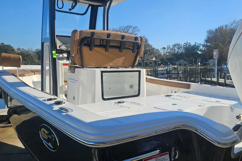 Slide: The Image of 2026 Sea Hunt BX 25 FS boat with sleek design, docked near a marina. - 6