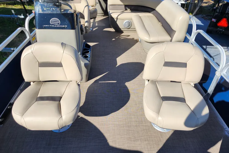 Slide: The Image of 2023 Sun Tracker Bass Buggy 18 DLX interior with beige seating and console. - 17